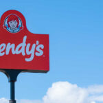 Wendy’s New Menu Stuns Competitors Wendy's restaurant sign against a clear blue sky