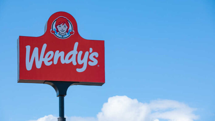 Wendy's restaurant sign against a clear blue sky