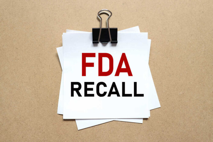 A notice labeled 'FDA RECALL' clipped to white papers on a brown background