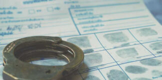 Handcuffs on a fingerprint document.