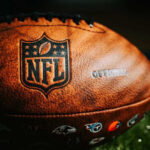 Close-up of an NFL football on grass.