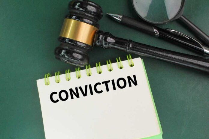 A gavel resting on a notepad with the word 'CONVICTION' written on it