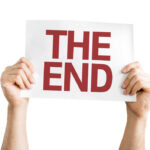 Hands holding a sign that reads 'THE END'