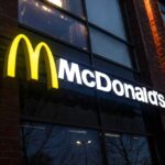 Illuminated McDonald's sign on a brick building at night