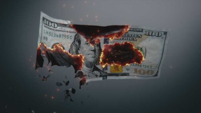 A hundred dollar bill appearing to burn and disintegrate