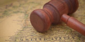 A wooden gavel resting on a map of the United States