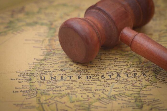 A wooden gavel resting on a map of the United States