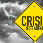 IRS Staffing CRISIS — Tax Season at Risk Yellow sign reading Crisis Just Ahead with stormy sky