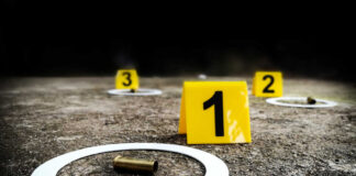 Crime scene with evidence markers and a bullet casing on the ground