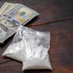 Narcos DUMP $5.6M Cocaine — Then Vanish Completely Bundles of cash next to bags of white powder on a wooden surface