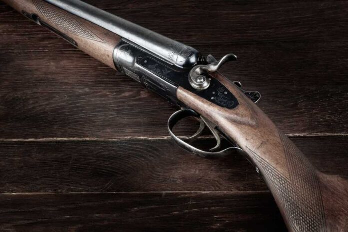 shutterstock_2499184733.jpg Close-up of a vintage shotgun with a wooden stock and metallic components