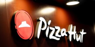 Illuminated Pizza Hut sign on a dark background