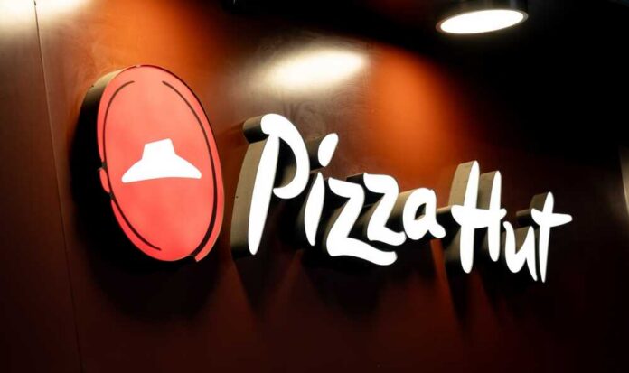 Illuminated Pizza Hut sign on a dark background