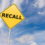 DOORS FLYING OPEN: 141K Recalled Yellow sign with RECALL text against blue sky.
