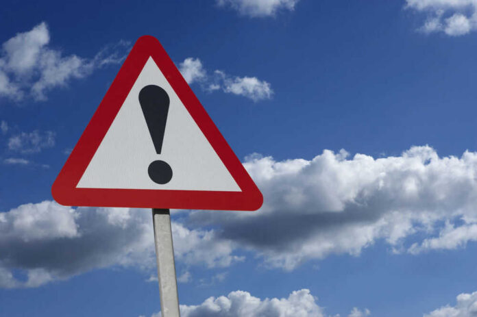 shutterstock_539658352.jpg Warning sign with exclamation mark against sky