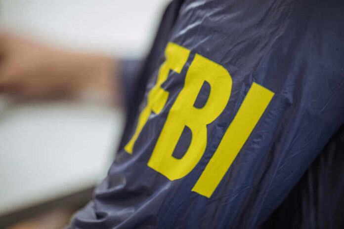 shutterstock_612694196.jpg Person wearing FBI jacket, letters in yellow.