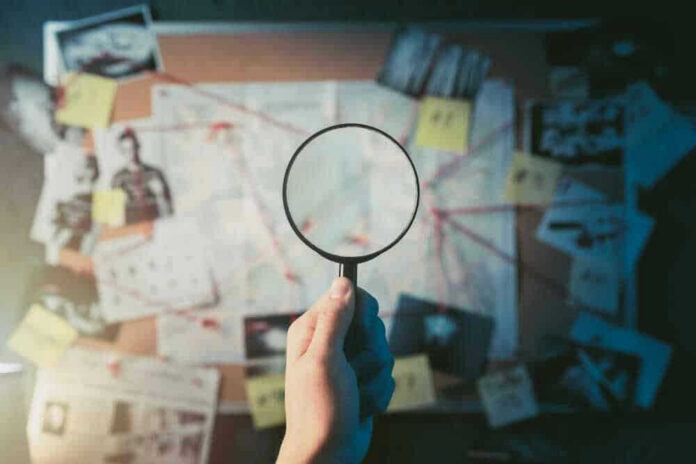 Magnifying glass over investigation board with photos and strings.