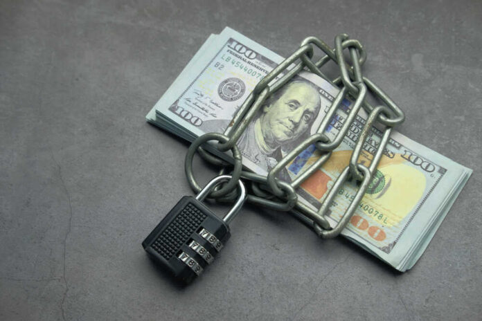 A stack of cash secured with a chain and padlock