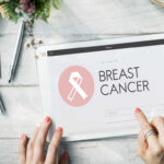 Person using a tablet displaying a breast cancer awareness website