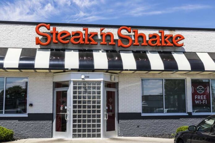 Exterior view of a Steak 'n Shake restaurant with a striped awning