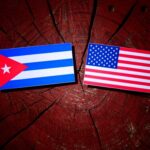 TRUMP Again Floats “Friendly Takeover” Of Cuba Cuban and American flags placed on a wooden surface