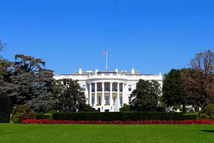 The White House with flags and trees.