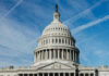 U.S. Capitol building dome against blue sky.