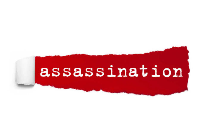 The word 'assassination' printed on a red torn paper background