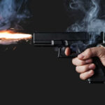 Midnight Gunfire Erupts Outside Popular Bar A hand holding a gun with smoke and a flash from the muzzle