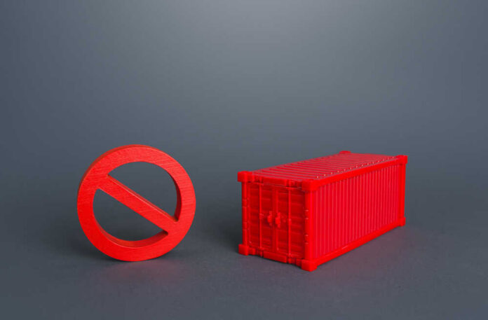 A red prohibition sign next to a red shipping container