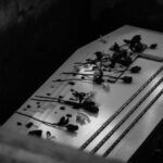 Coffin with flowers inside a dark burial plot.