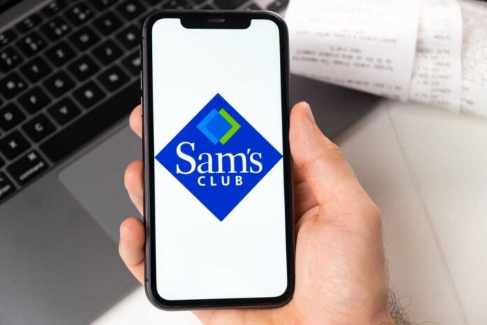 shutterstock_2116477337.jpg A hand holding a smartphone displaying the Sam's Club logo