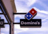 Dominos Pizza store sign with blue sky background