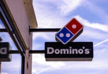 Dominos Pizza store sign with blue sky background
