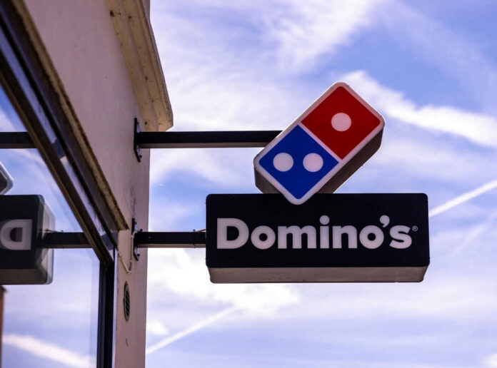 Dominos Pizza store sign with blue sky background