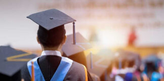 Graduates wearing caps and gowns in a ceremony.