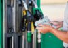 Person holding cash at a gas station while preparing to refuel