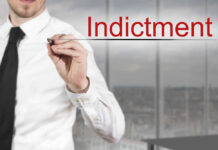 Businessman writing the word 'Indictment' in a modern office