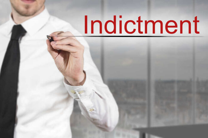 Businessman writing the word 'Indictment' in a modern office