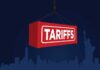 Red shipping container labeled 'TARIFFS' suspended above a city skyline
