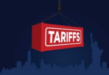 Tariff Shock Hits Used-Car Lots Red shipping container labeled 'TARIFFS' suspended above a city skyline