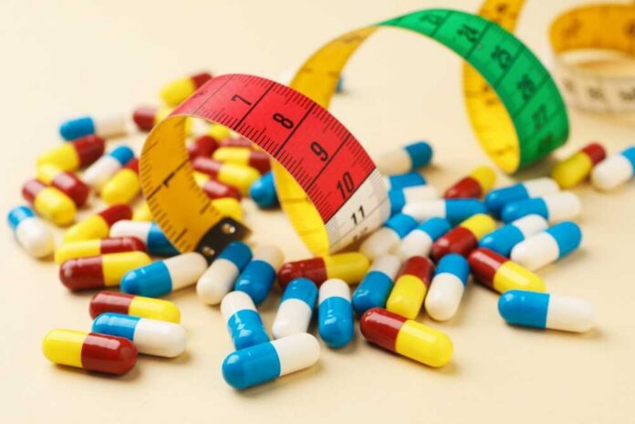 Colorful pills scattered around measuring tapes