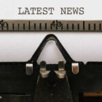 Close-up of a typewriter with a sheet of paper displaying the words 'LATEST NEWS'