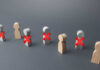 Starbucks SLASHES Even More Jobs — What’s Next? Wooden figures representing people with red crosses indicating exclusion