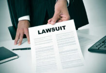 Businessman holding a lawsuit document in an office