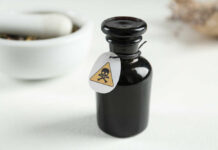 Black bottle labeled with a poison warning next to a mortar and pestle
