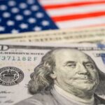Retirement Shakeup: Trump’s $1,000 Boost Unveiled Close-up of a hundred dollar bill in front of an American flag