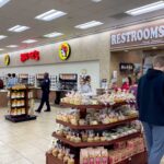 Interior of a Buc-ee's convenience store with snack displays and a restroom sign