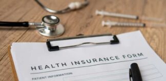Health insurance form with a pen, stethoscope, and syringes on a wooden surface