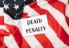 A sign reading 'DEATH PENALTY' placed on an American flag